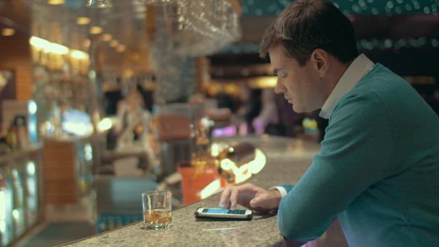 Drinking at the bar and texting.