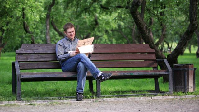 Reading a newspaper in the park.