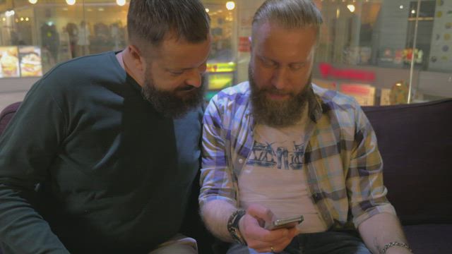 Bearded friends browsing a phone.