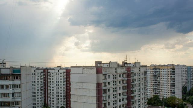 Apartment buildings below grey clouds.