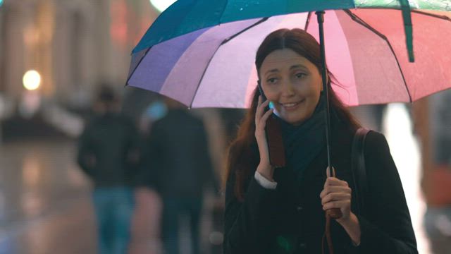 Chatting on the phone under an umbrella.
