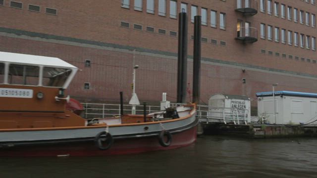 Barges docked along a city river.