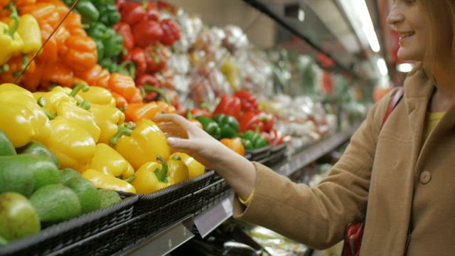 Woman buying peppers.