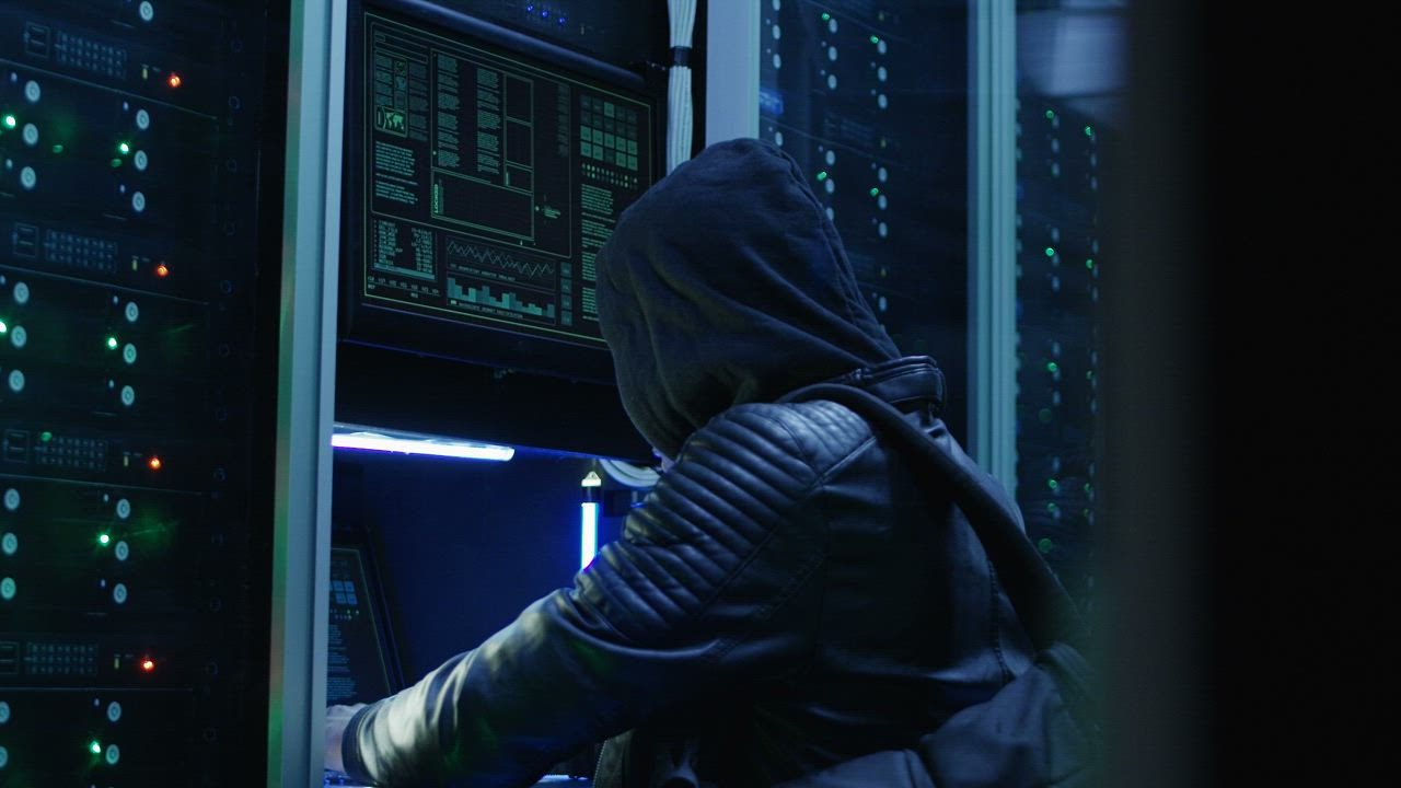 Man in hoodie hacking a data center - Free Stock Video