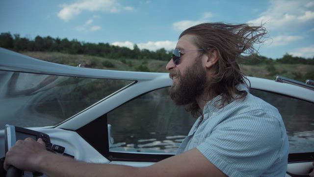 A man driving a speedboat in the lake.