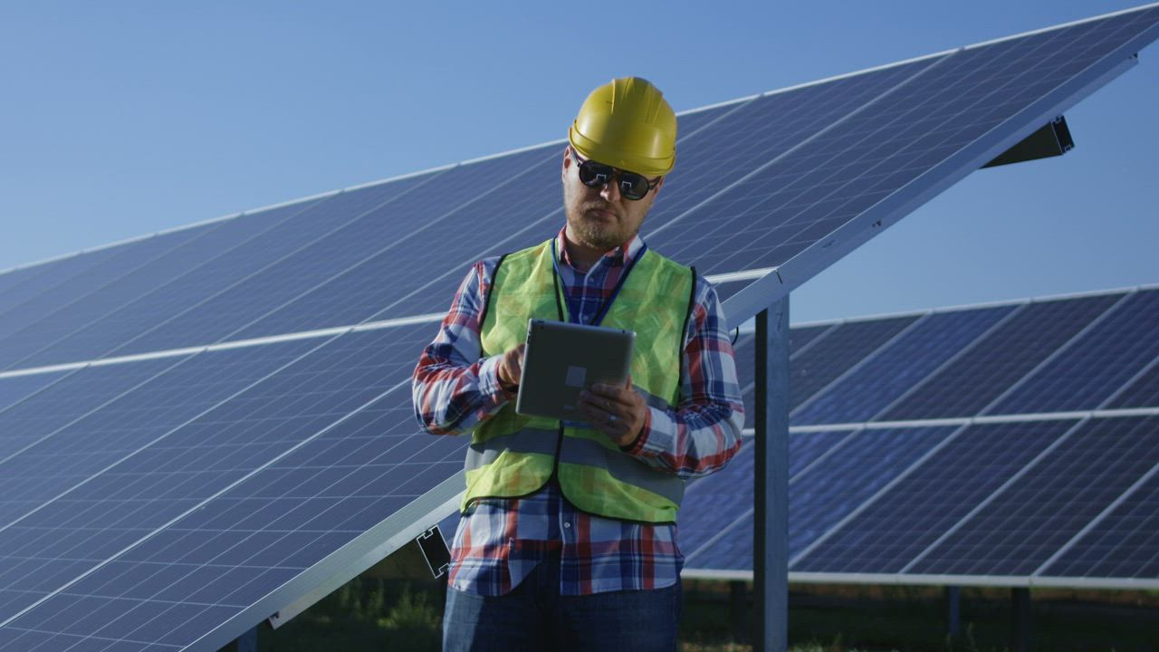 Engineer with a tablet in the solar panels field - Free Stock Video