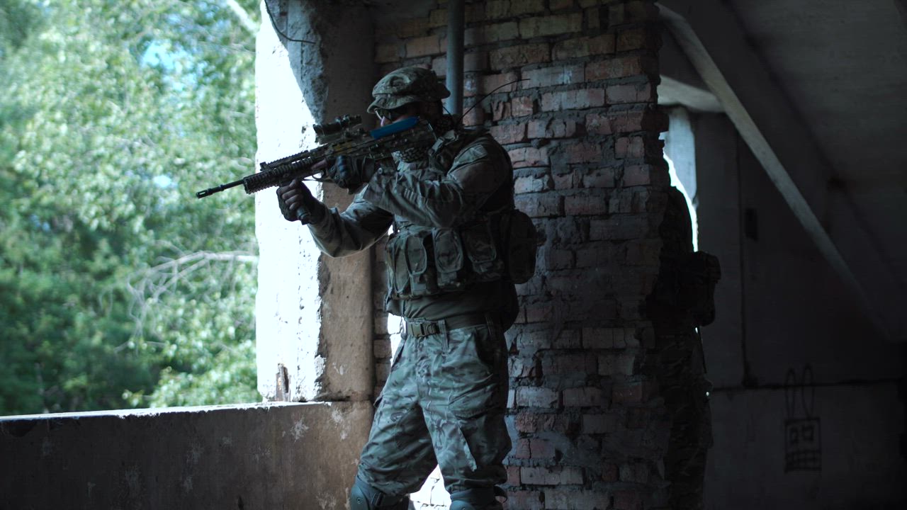 Soldier near a window in an abandoned building - Free Stock Video