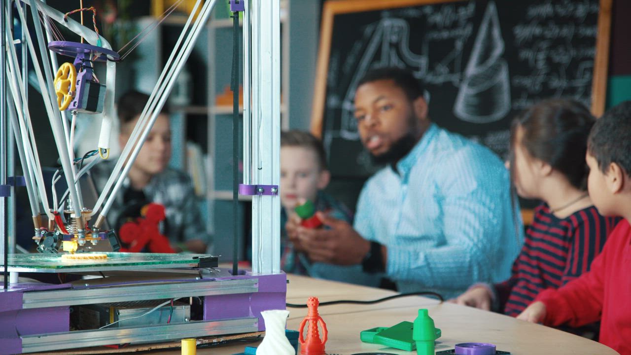 Teacher explaining 3-D printer to kids - Free Stock Video