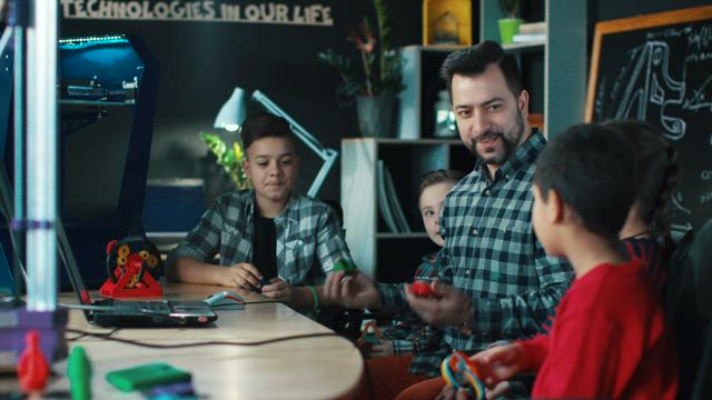 Teacher explaining to kids 3-D technology.