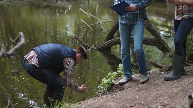 Collecting samples from polluted lake.