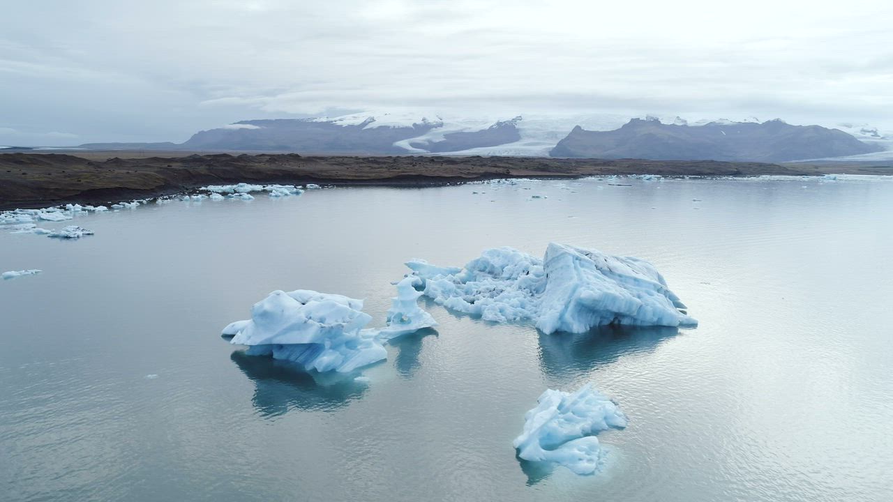 Iceberg floating in the ocean near the coast - Free Stock Video
