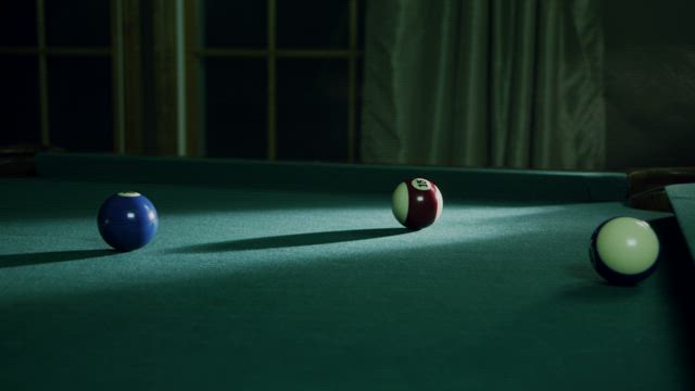 Putting a ball into a table pocket.