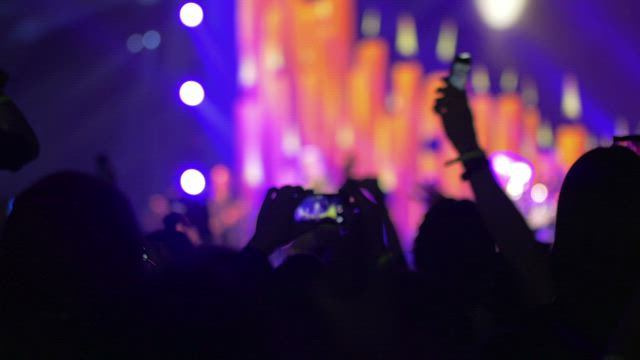 Waving phones at a concert.