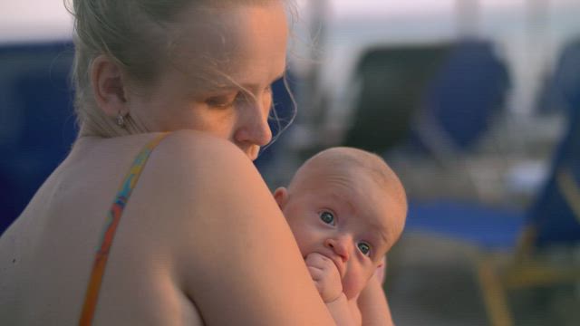 Mother carefully holding her newborn child.