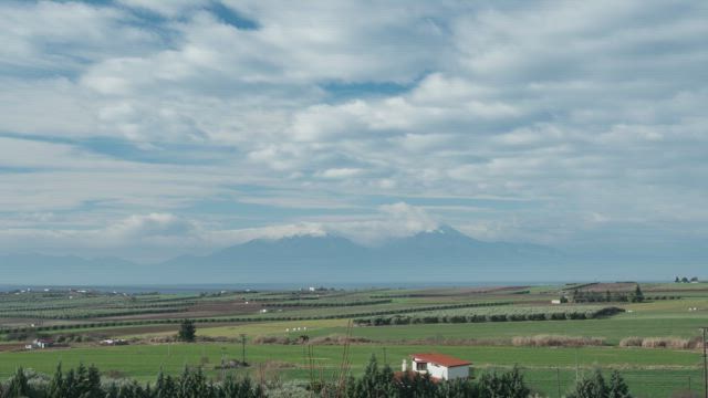 Farmlands below a mountain.