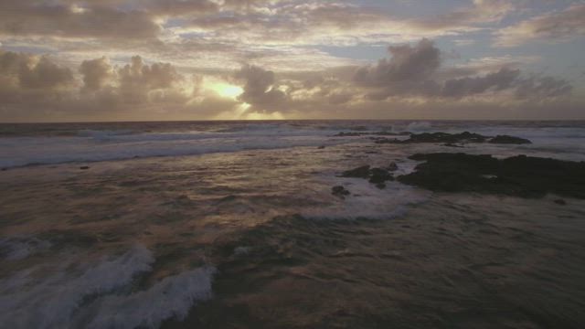 Flying above waves at sunset.