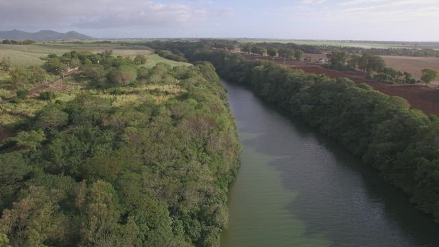 Gentle river water between farmland.