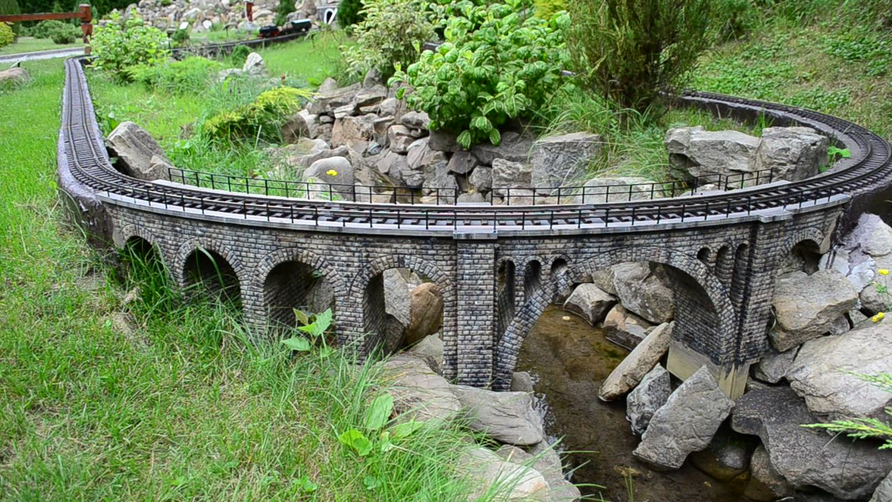 Model train heading over a bridge - Free Stock Video