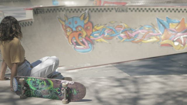 Skater in a bowl with friend.