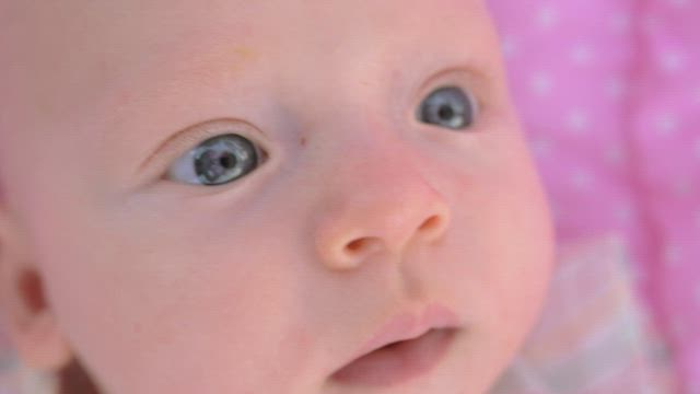 Closeup of a young baby looking around.