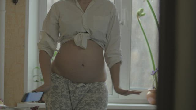 Pregnant woman dancing inside.