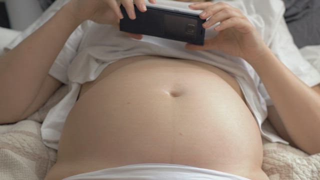 Pregnant woman taking a photo.