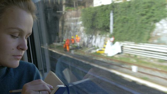 Woman drawing during a train journey.
