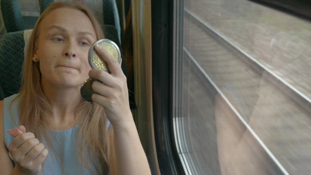 Applying makeup on a train.