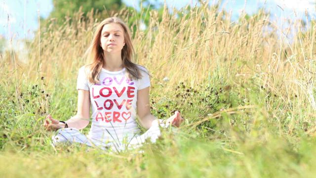Young woman meditating in a field.
