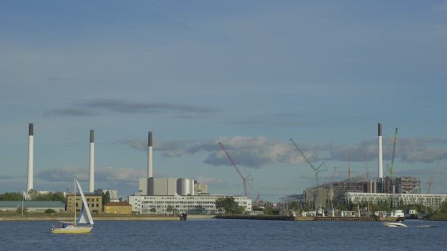 Boats heading past an industrial port.