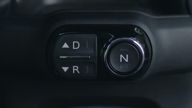 Woman pressing the reverse button on a dashboard.