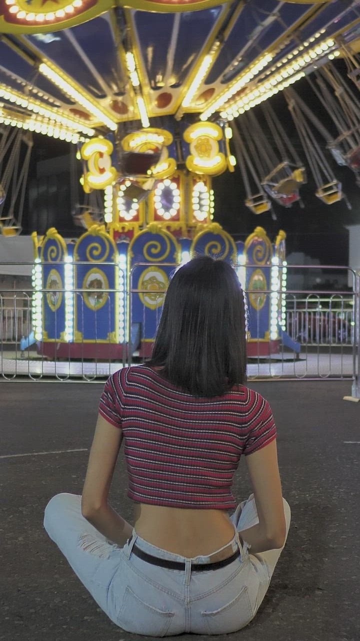 Motionless woman sitting on the floor watching Mechanical Flying Chairs ...