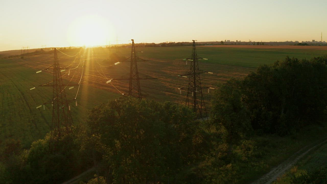 Electric power lines in the field at sunset - Free Stock Video