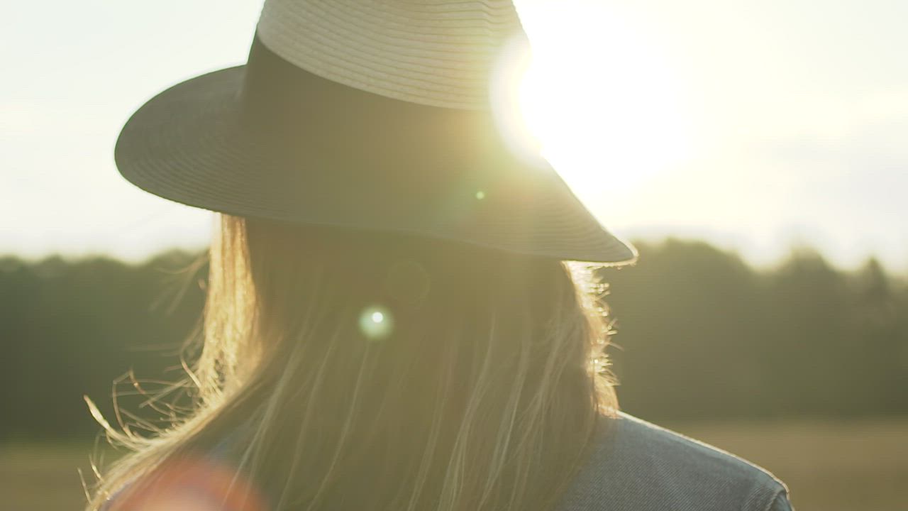 Woman with a hat looking at the sunset - Free Stock Video