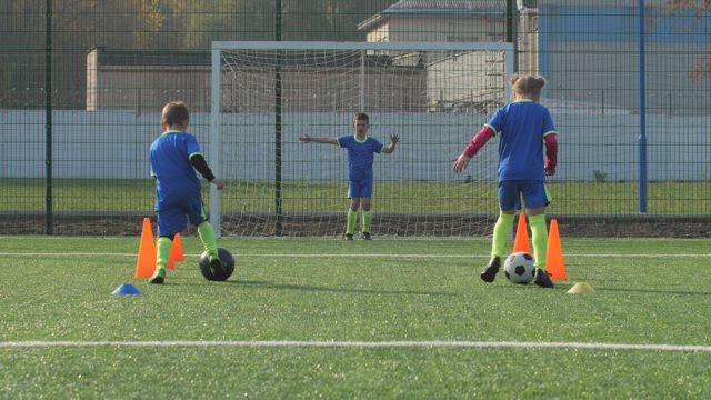 Soccer players training against a Goalie.