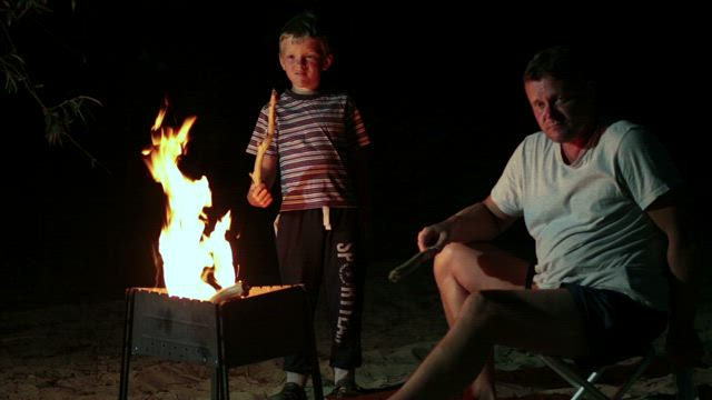 Family resting by a campfire.