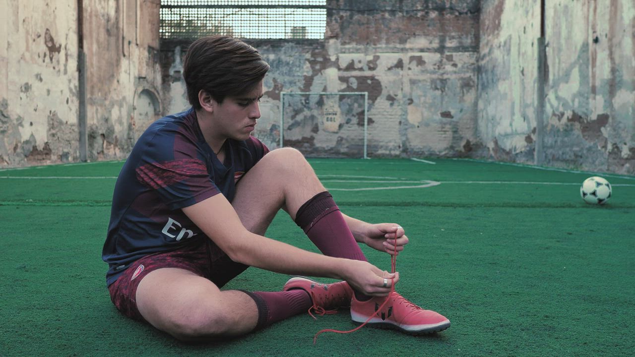 Soccer player ties his laces - Free Stock Video