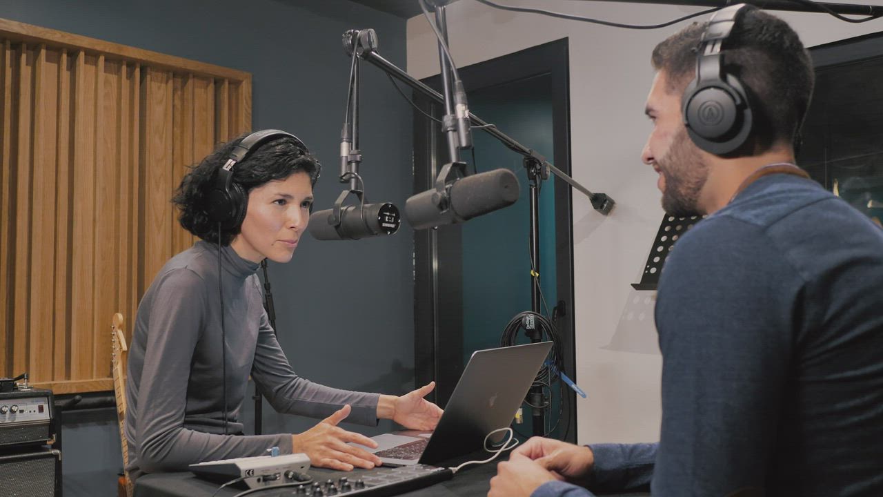 Hosts recording a podcast