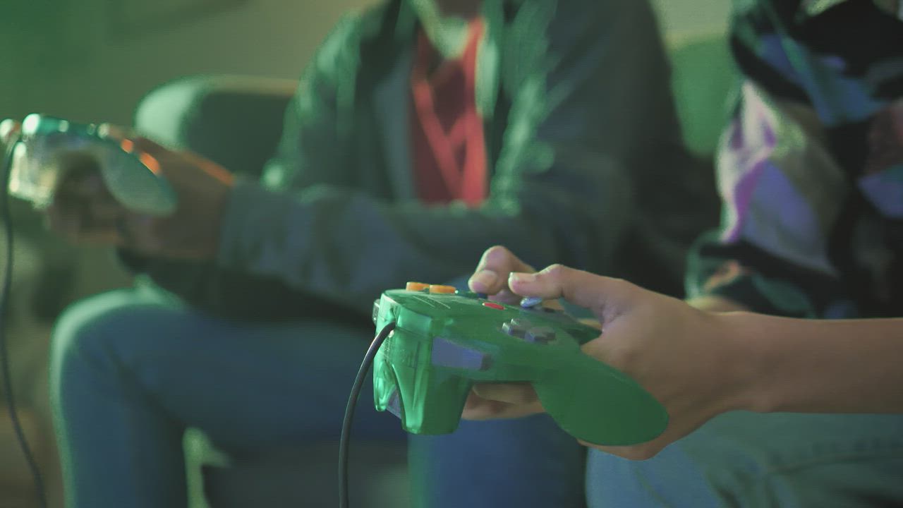 Two players pressing the buttons of a video game control - Free Stock Video