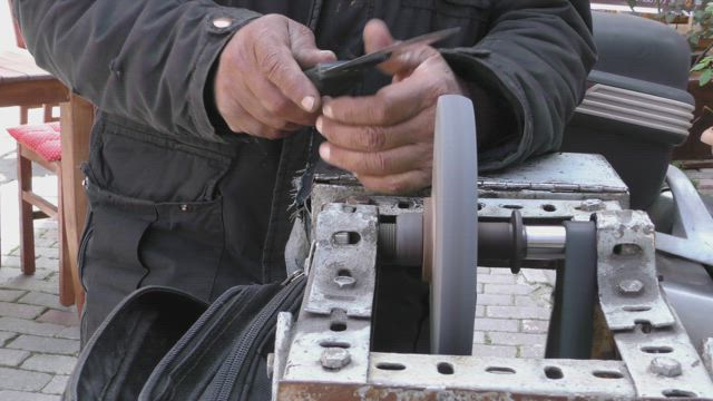 Worker sharpening his tool on a machine.