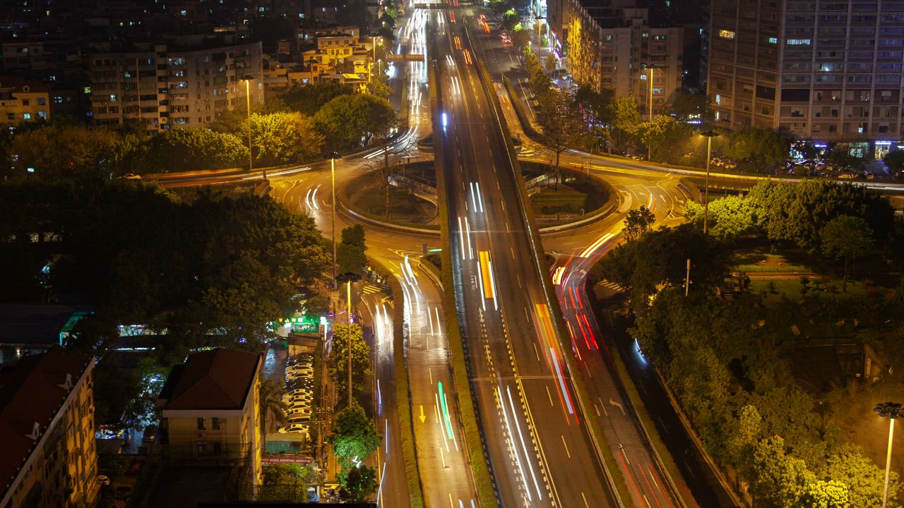 Roundabout and overpass with fast traffic at night - Free Stock Video