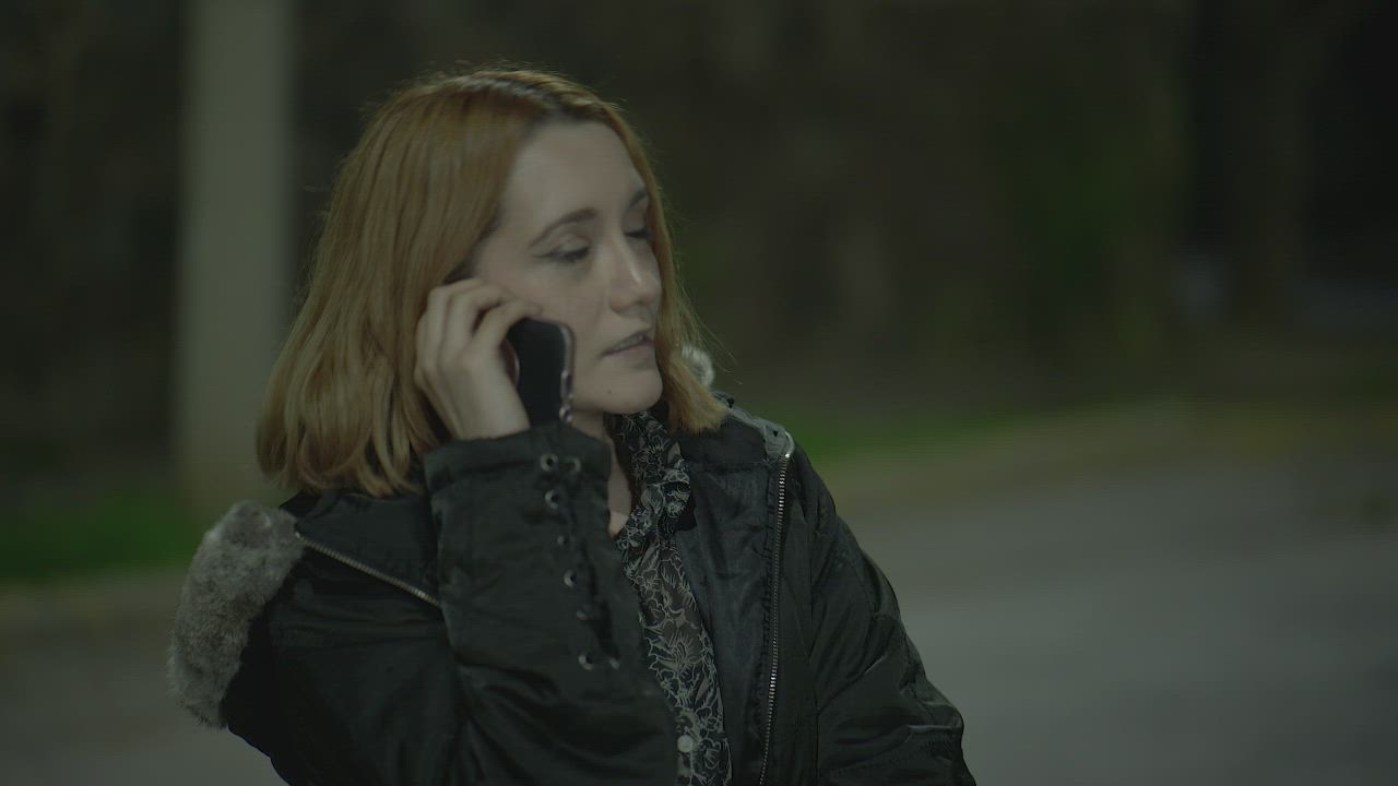 A woman talking on her phone on a dark street