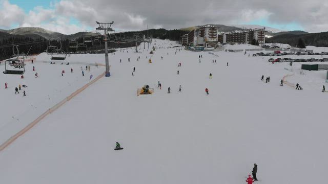Sky lift and skiers in the snowy mountain.