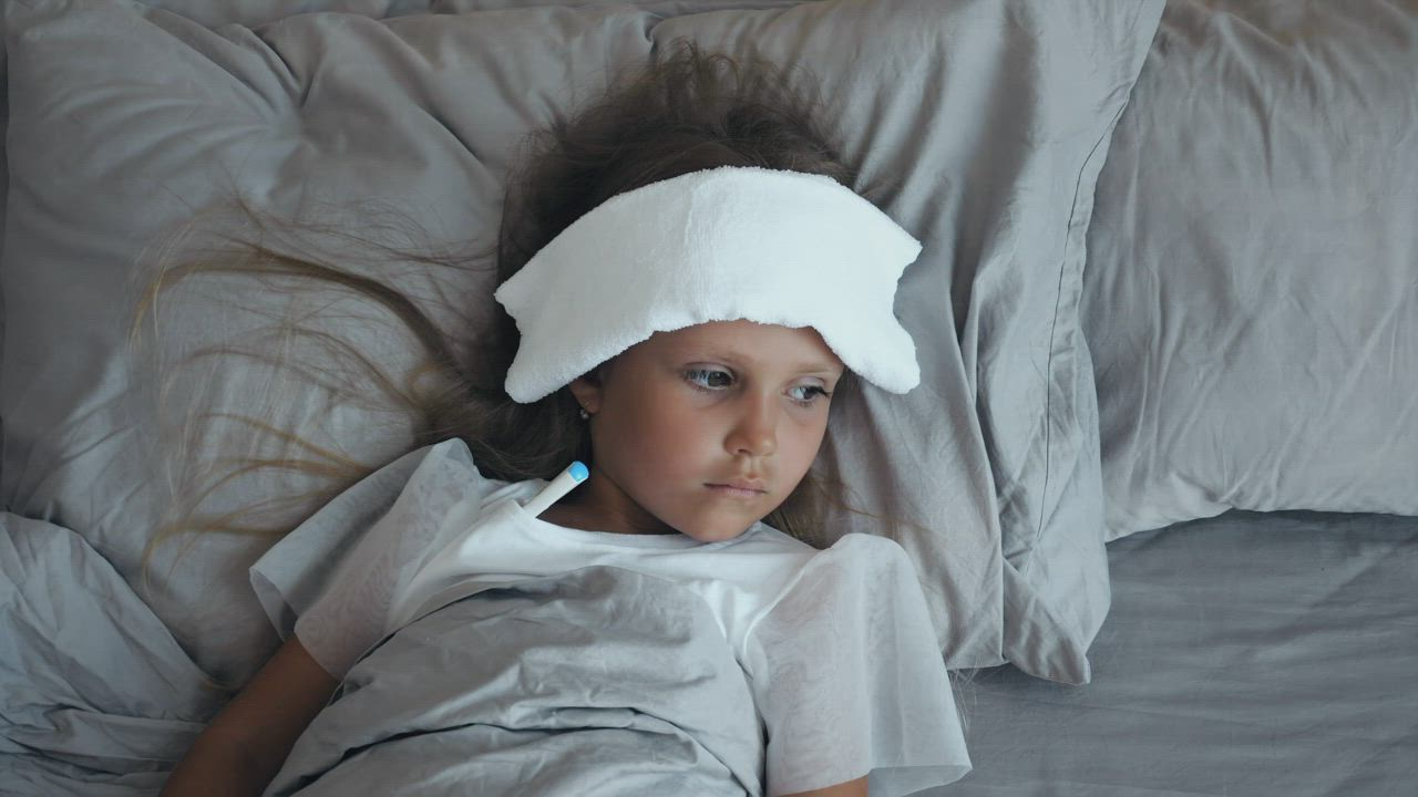 Sick child with a thermometer and a compress - Free Stock Video