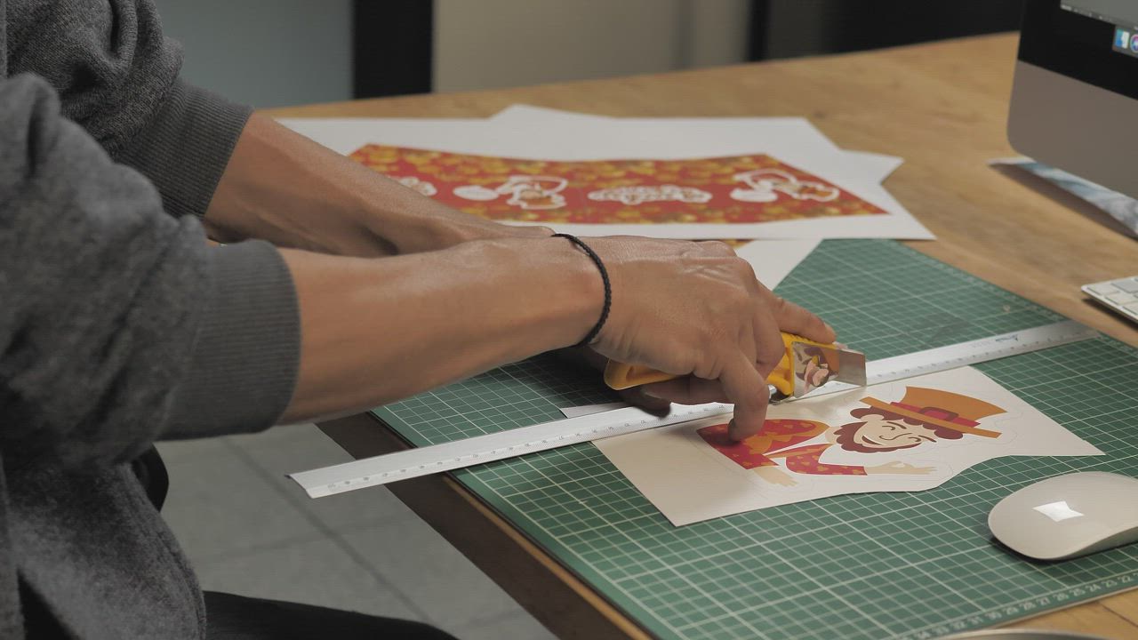 Man's hands cut a printed illustration with a cutter - Free Stock Video
