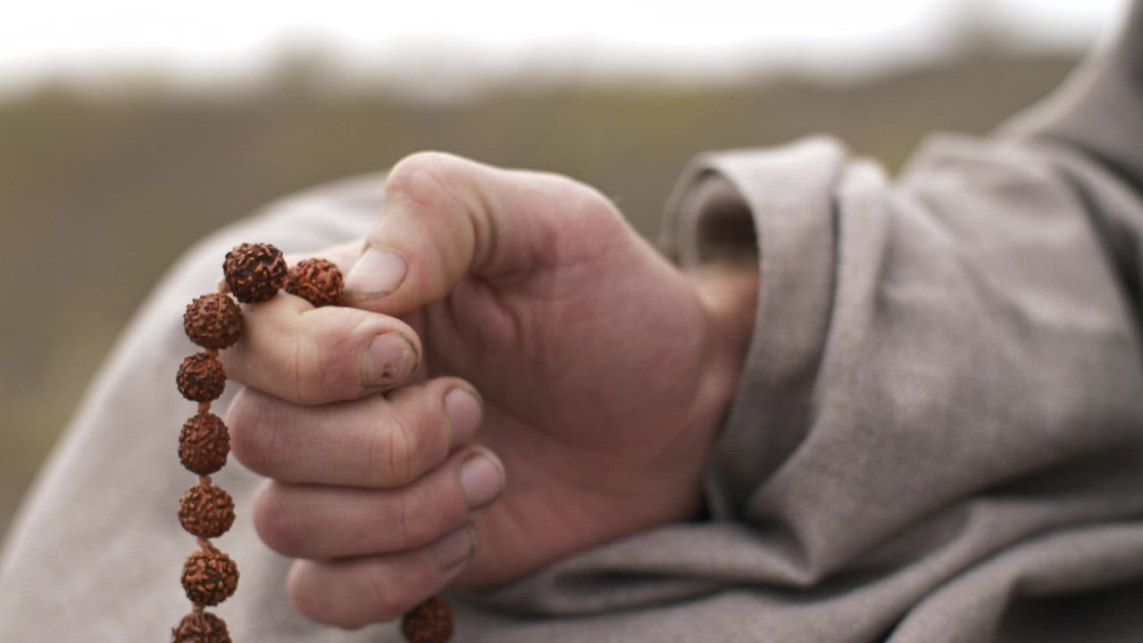 Hand of a man praying with beads - Free Stock Video