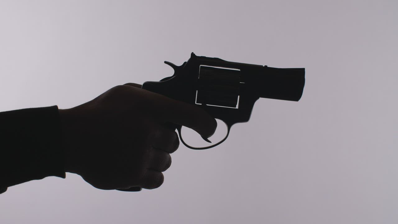 Silhouette of a hand firing a revolver - Free Stock Video