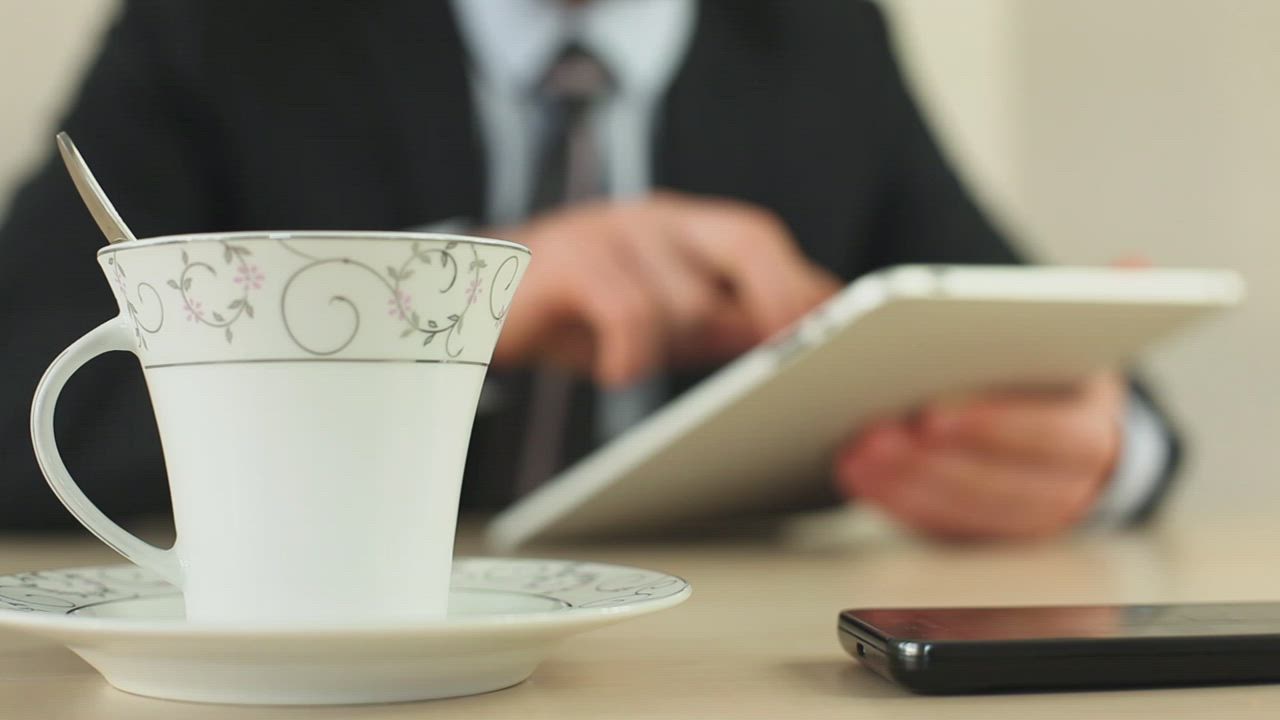 Businessman with a tablet drinking coffee - Free Stock Video