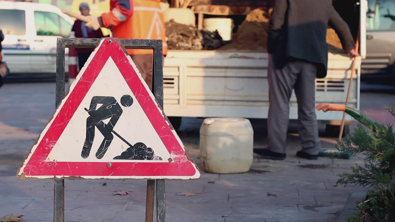 Men cleaning a street with a dirt road signs - Free Stock Video
