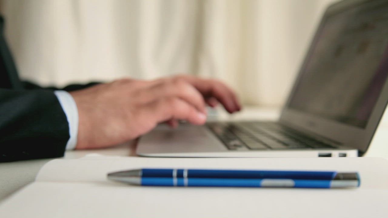 Men taking note while browsing in a laptop - Free Stock Video